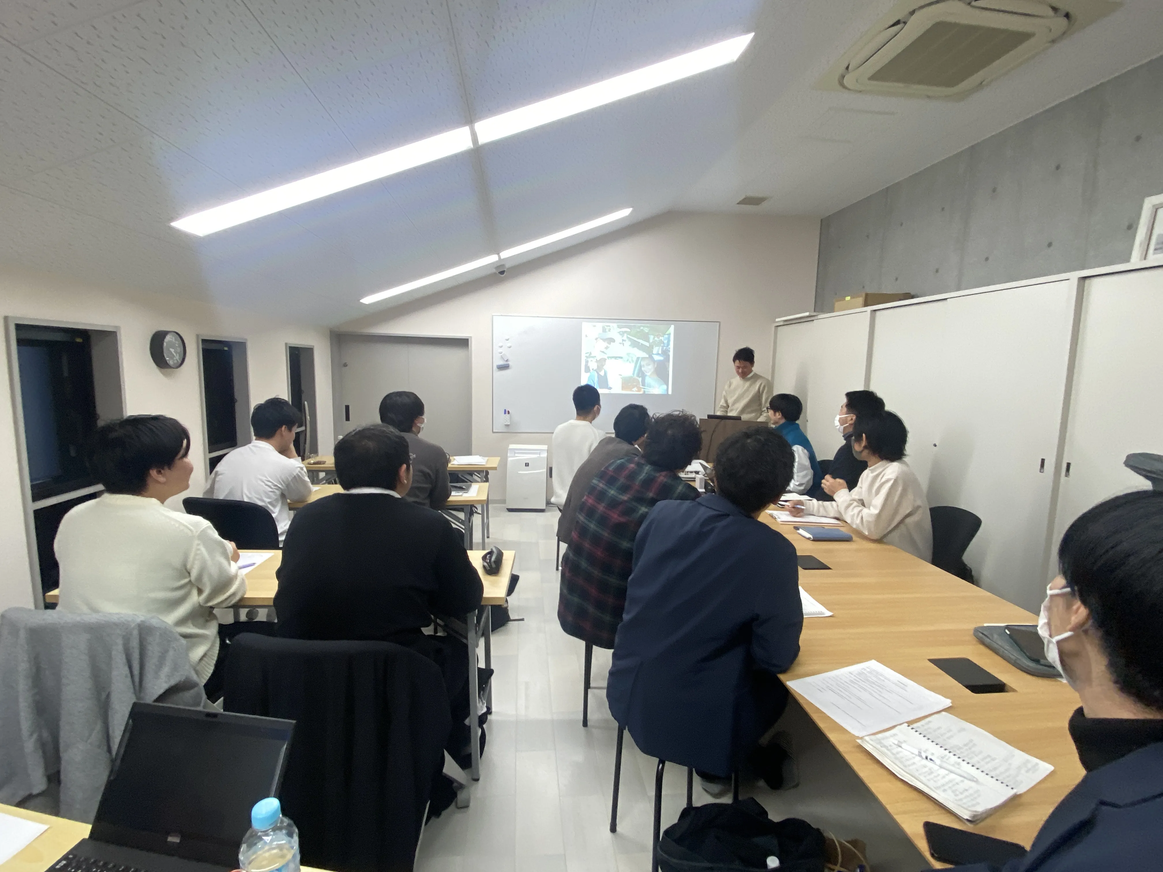 職員が会議室でプロジェクターを使用して研修を行っている様子
