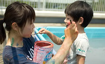 横浜りとるぱんぷきんずの園児と保育士が絵の具で遊んでいる様子