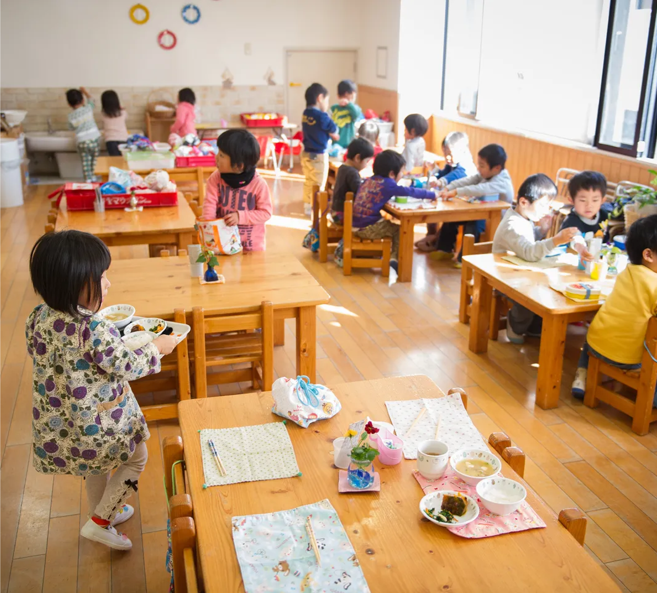 遊び道具を運ぶ保育園児