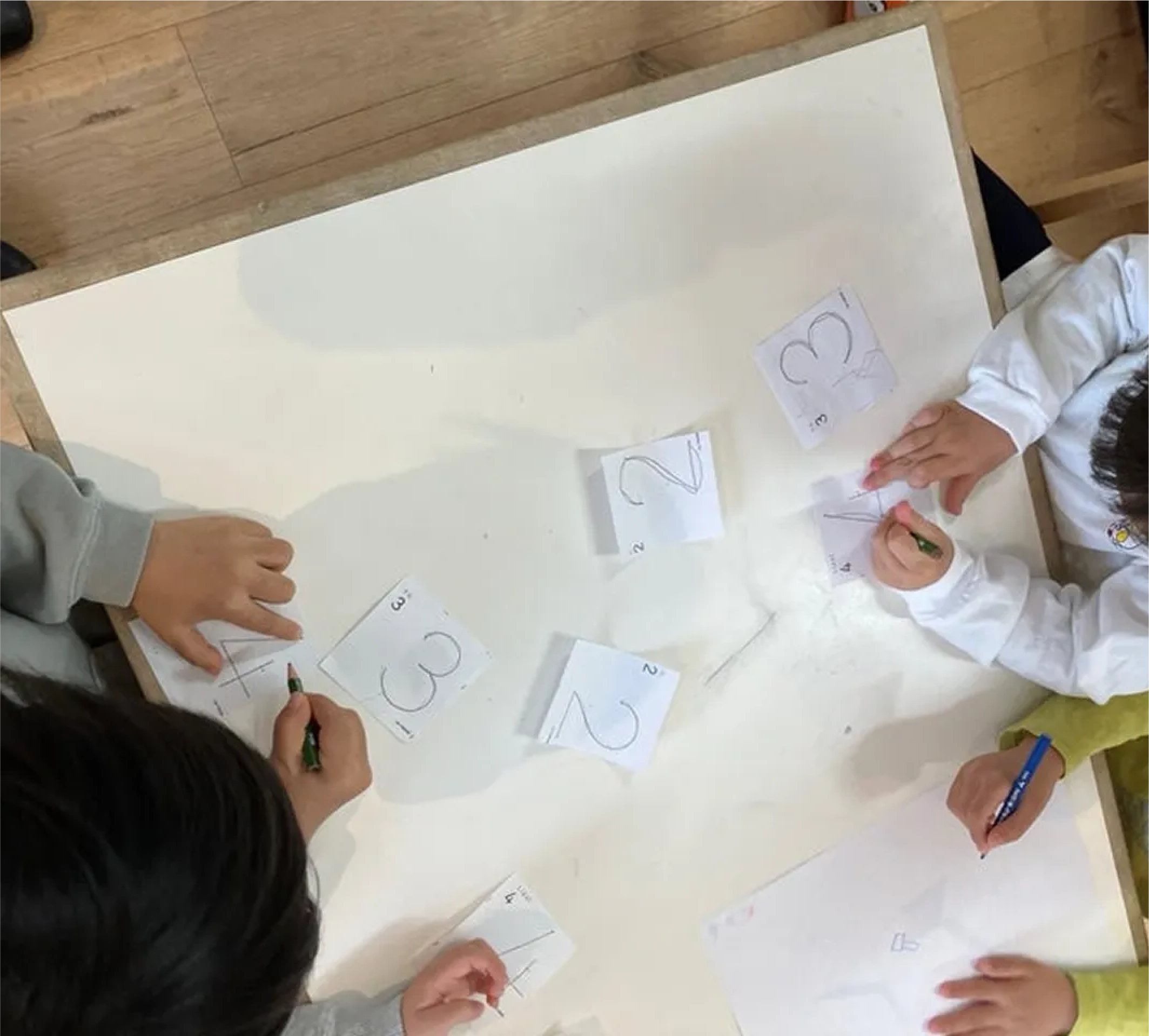 西原りとるぱんぷきんずの園児が数字を書く練習をしている様子